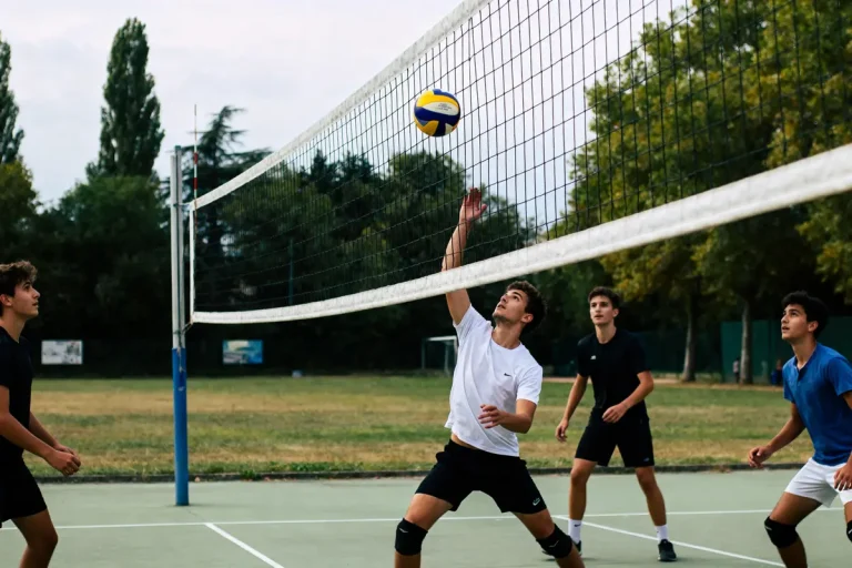 Quatre jeunes hommes jouent au volley-ball en extérieur, un sautant pour toucher le ballon.