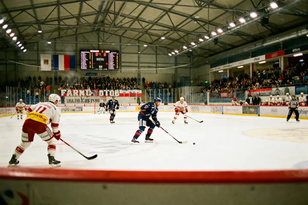 Match de hockey sur glace en cours, joueurs et spectateurs dans une patinoire couverte remplie.