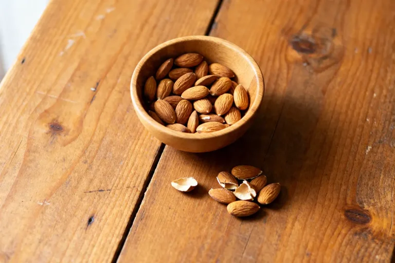 Bol d'amandes sur table en bois soulignant le danger de manger trop d'amandes