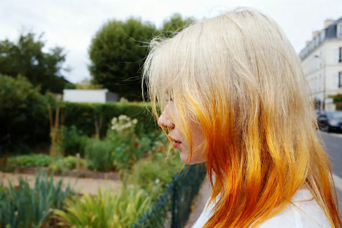 Cheveux colorés décolorés par l'effet de la Bétadine en extérieur verdoyant