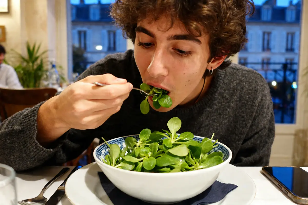 Personne mangeant de la mâche le soir dans un restaurant au décor urbain élégant