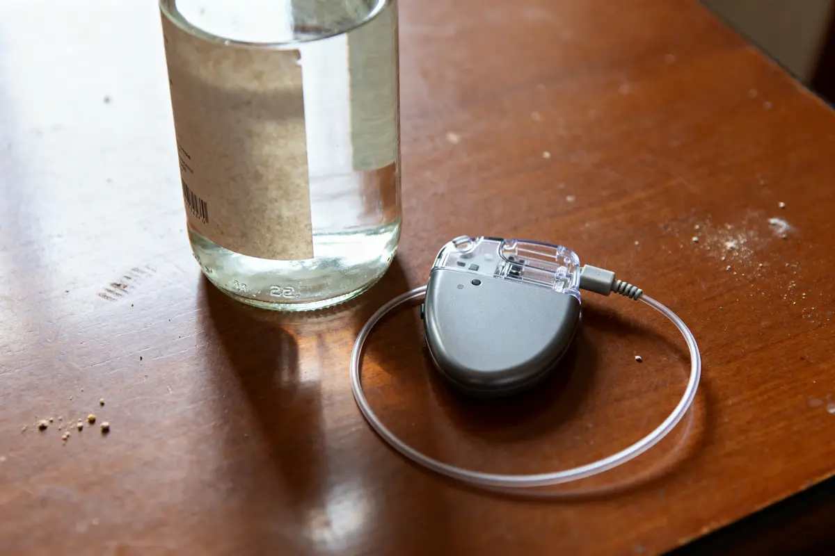 Pacemaker posé à côté d'une bouteille d'alcool sur une table en bois brun