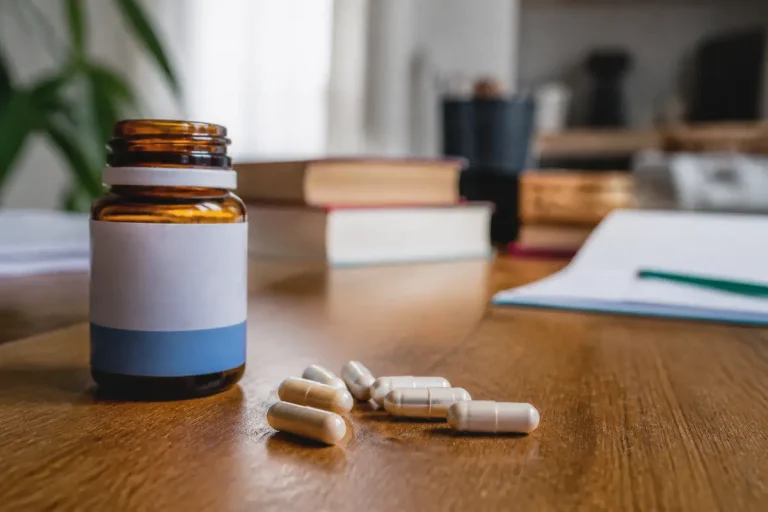 Flacon ouvert avec gélules, expliquant la posologie du Lexomil sur une table en bois