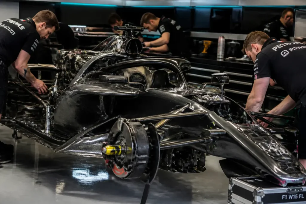 Techniciens travaillant sur une Formule 1 en atelier, explorant le prix des Formule 1.