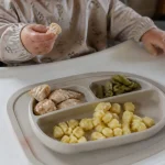 Repas équilibré pour un bébé de 8 mois avec légumes, poulet et gnocchis sur plateau
