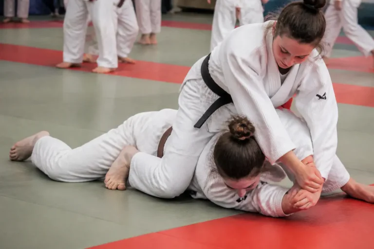 Deux judokas féminines réalisant une prise de judo lors d'un entraînement sur tatami